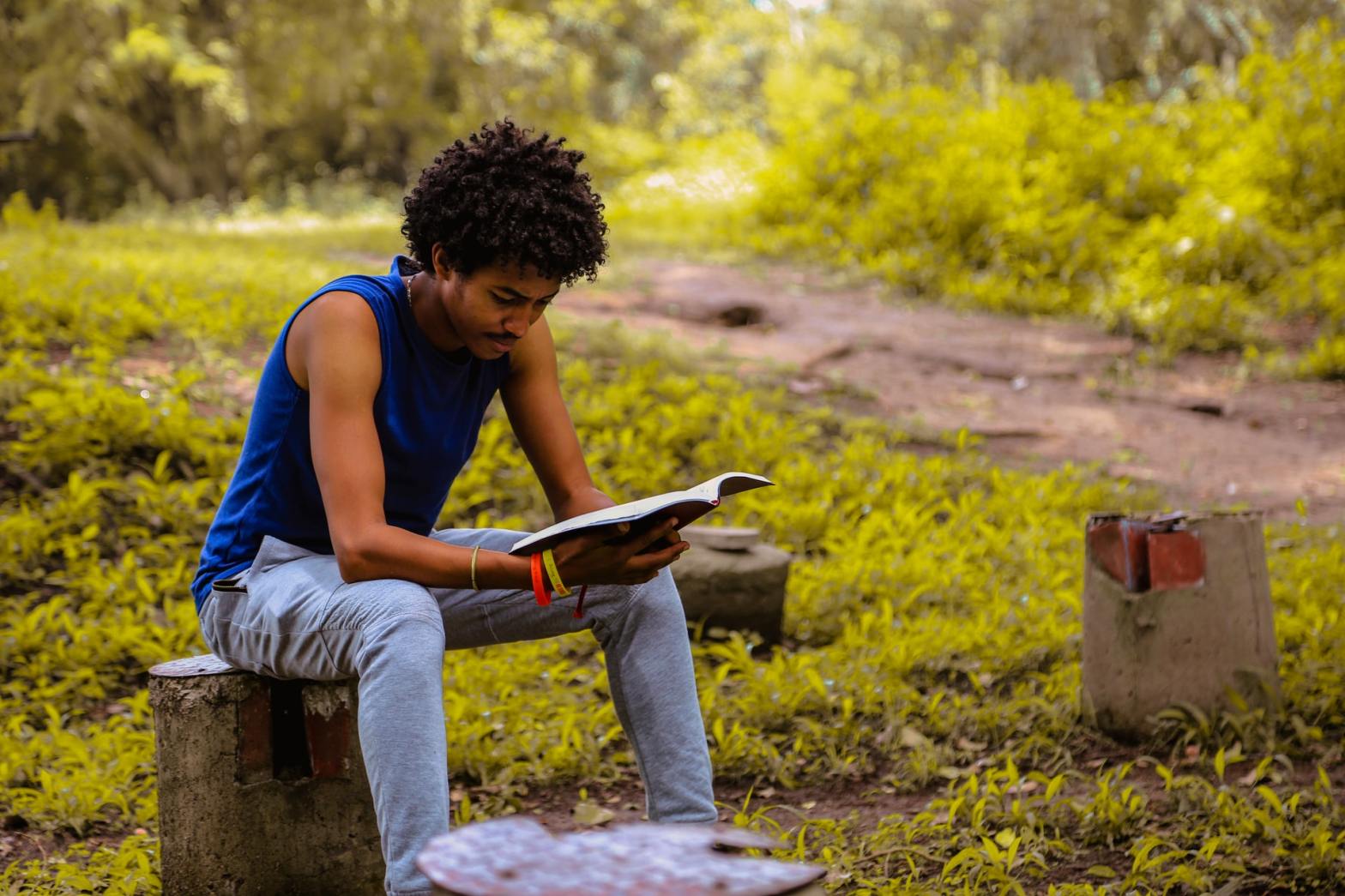 A guy reading a book outdoor