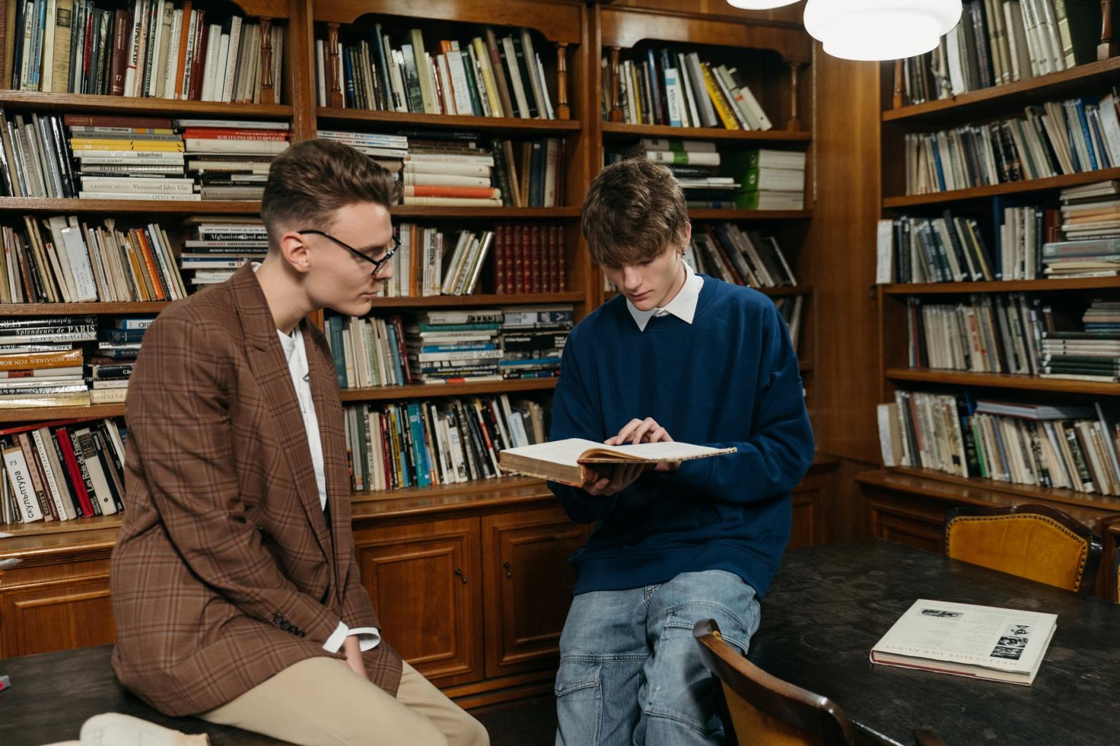 Two guys reading in the library